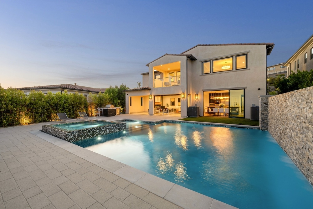 Maison de Luxe avec Piscine et Spa Design au Crépuscule Maison moderne de luxe avec piscine illuminée et spa au crépuscule, terrasse aménagée et façade élégante.